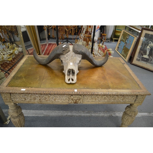 332 - A Victorian carved and painted two drawer writing table with leather inset top.