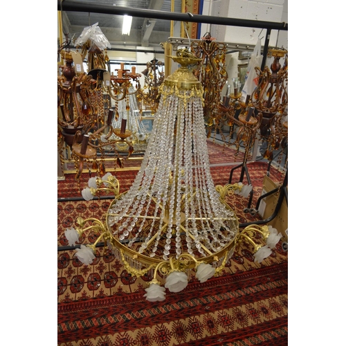 337 - A large brass and cut crystal chandelier with scrolling branches having frosted glass shades.