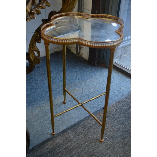 358 - A gilt metal quatrefoil shaped occasional table with mirrored top.