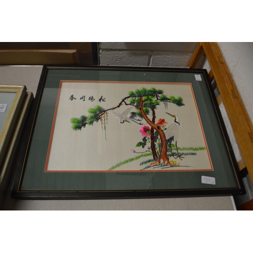 461 - A pair of colourful Chinese embroidered pictures depicting exotic birds on branches.