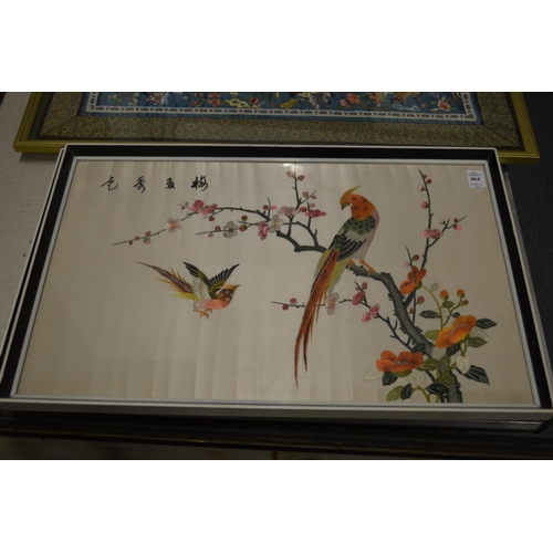 464 - A pair of colourful Chinese embroidered pictures depicting exotic birds on branches.