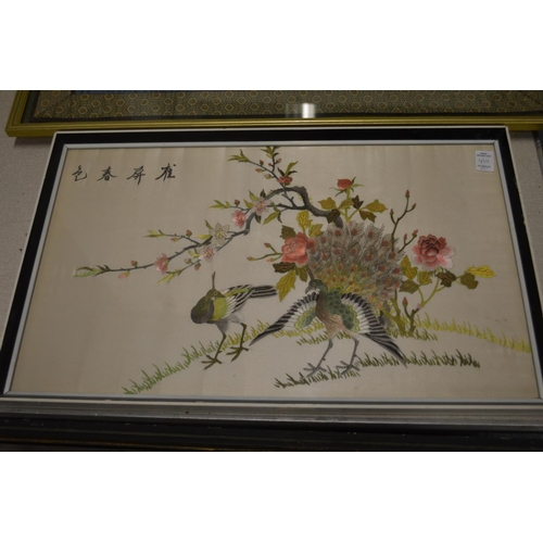 464 - A pair of colourful Chinese embroidered pictures depicting exotic birds on branches.