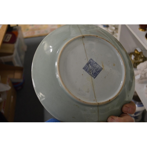 523 - A pair of Chinese celadon ground circular dishes painted with birds and flowers (both repaired).