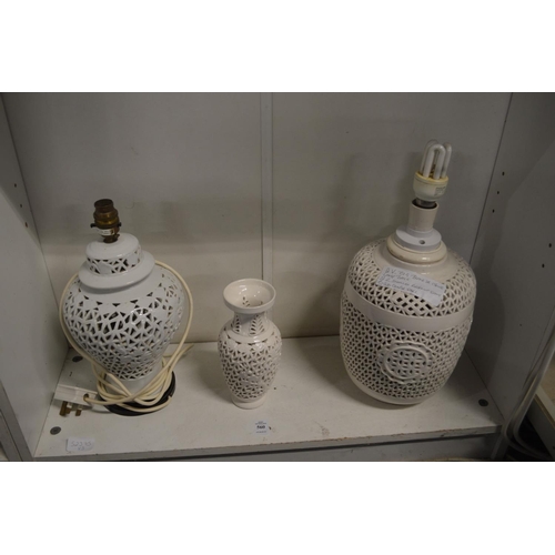 560 - Two blanc de chine lamp bases and a similar vase, all with pierced decoration.