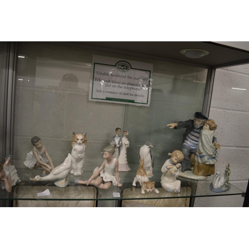 573 - A large Nao group of a fisherman and a young girl together with Lladro and similar items.