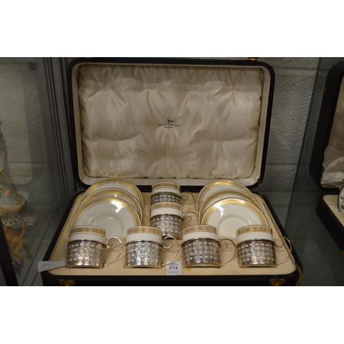 574 - A Wedgwood cased set of six gilt decorated coffee cans and saucers with pierced silver holders.