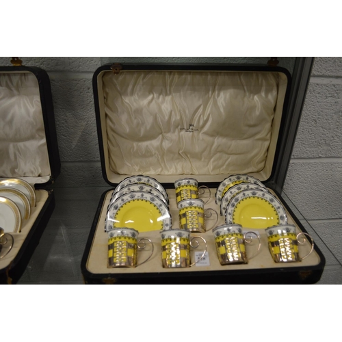 575 - A cased set of six Aynsley porcelain coffee cans and saucers with pierced silver holders.