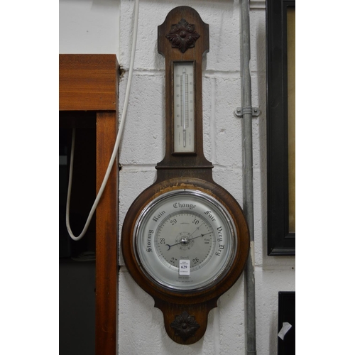 629 - An oak cased aneroid barometer and thermometer.