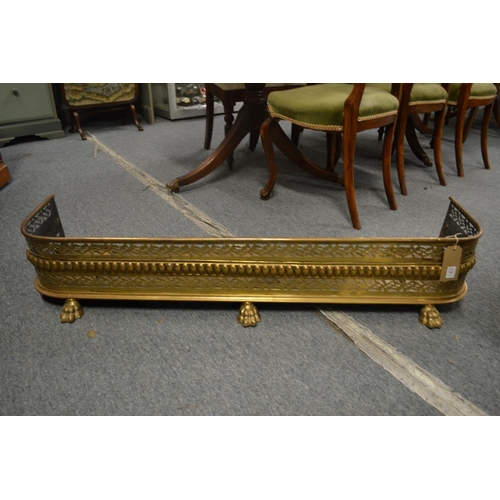 761 - A Regency pierced brass fender with pierced decoration supported on three cast brass claw feet, 3' 1... 