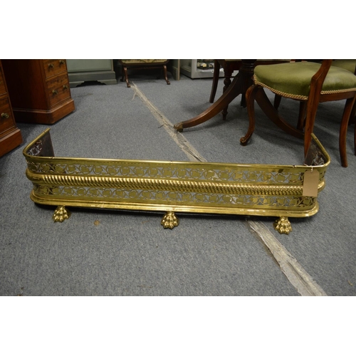 763 - A 19th century brass fender with pierced fretwork front on brass claw feet, 3'7