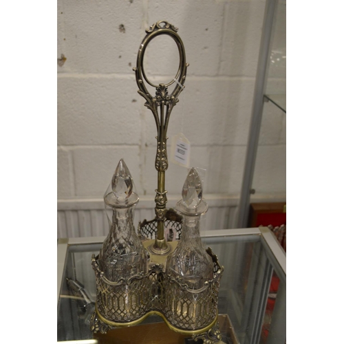 833 - A plated three bottle cruet containing a pair of cut glass decanters.