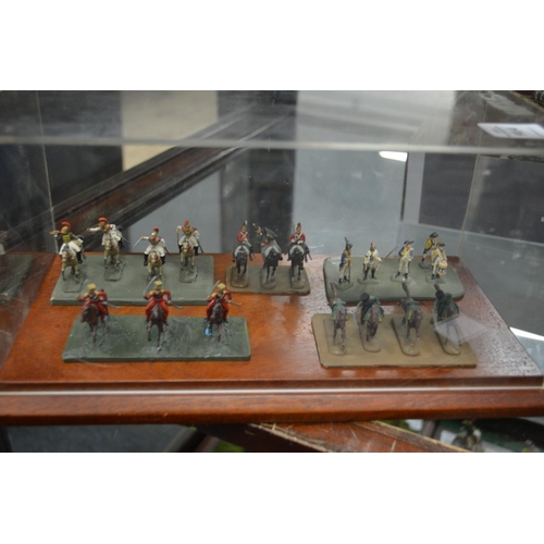 914 - Perspex case containing five sets of miniature military figures.