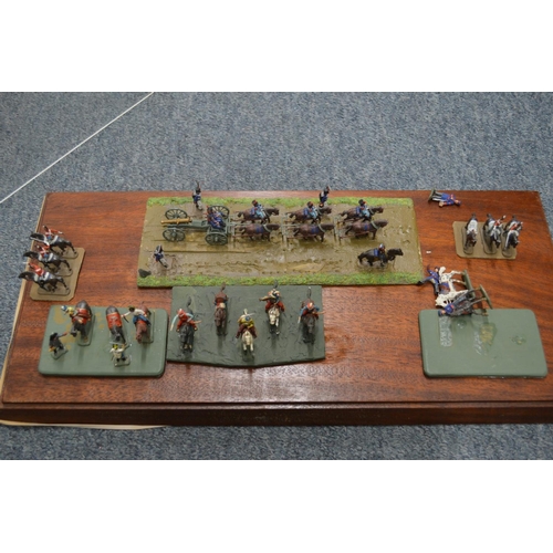 915 - Large perspex case containing various sets of military figures on wooden bases.