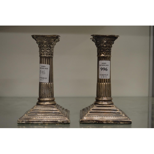 996 - A pair of silver corinthian column candlesticks.