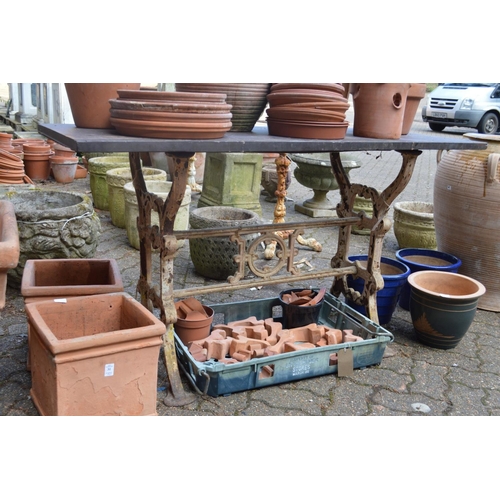 27 - A slate topped garden table with cast iron base.