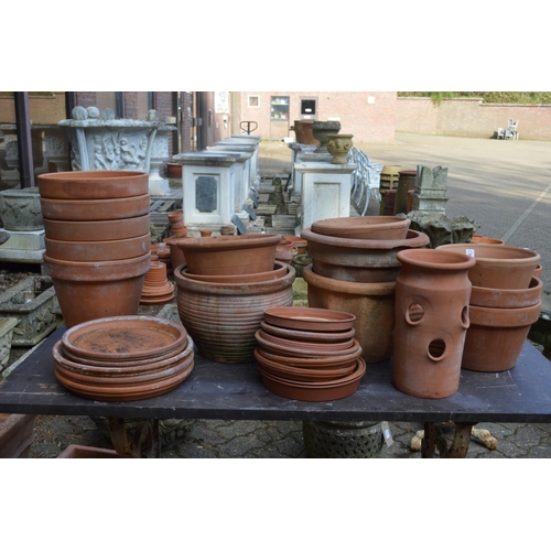 28 - A quantity of terracotta plant pots with stands.