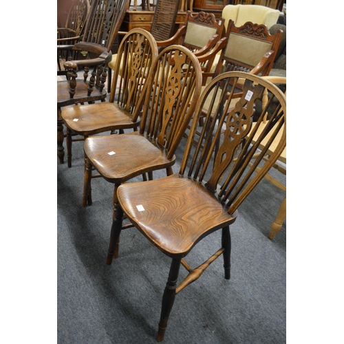 324 - Three beech, ash and elm wheelback single dining chairs.