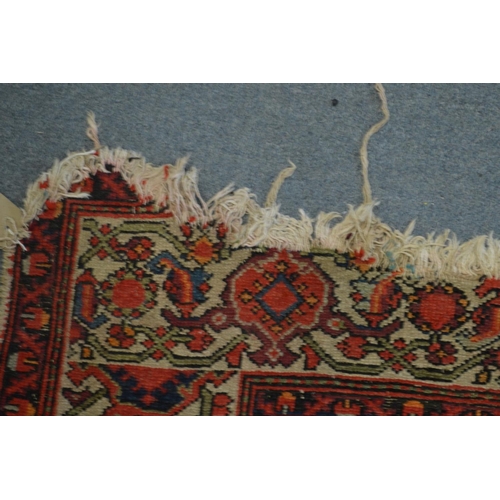 363 - A Persian carpet, red ground with stylised decoration, worn and damaged 185cm x 130cm.