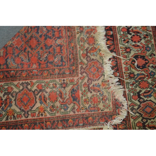 363 - A Persian carpet, red ground with stylised decoration, worn and damaged 185cm x 130cm.