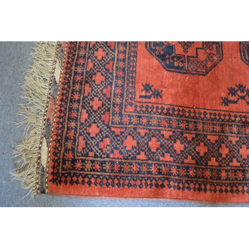 374 - A large Bokhara style carpet, red ground with stylised decoration 233cm x 177cm.