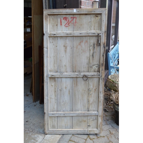 57 - A rustic old pine door with wrought iron fittings.