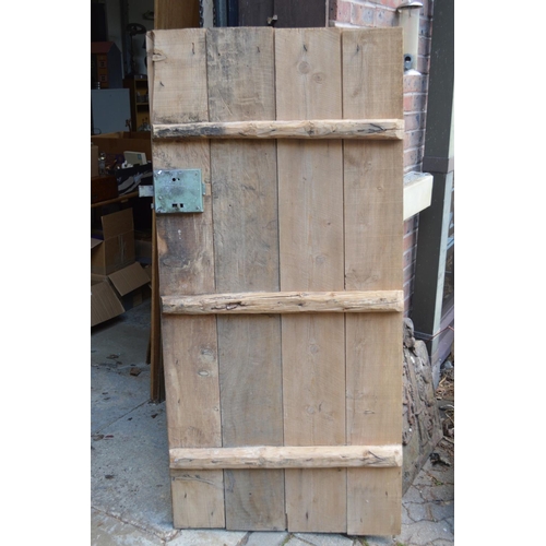 57 - A rustic old pine door with wrought iron fittings.