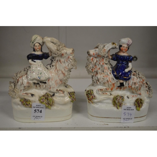 574 - A pair of Staffordshire figures of girls on goats.