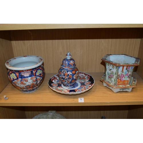 79 - A Chinese famille rose hexagonal shaped jardiniere stand and three pieces of Imari porcelain.