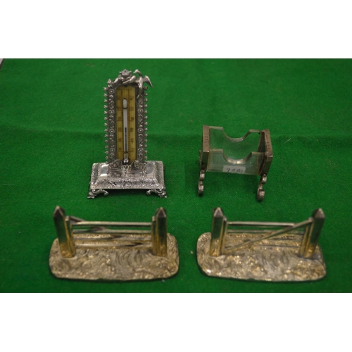 900 - A silver desk thermometer, silver mounted glass match striker and a pair of novelty five bar gate kn... 