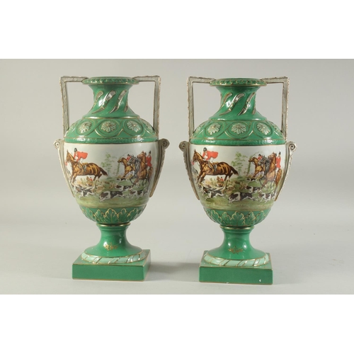 1151 - A PAIR OF SEVRES DESIGN GREEN GROUND HUNTING VASES with looped handles on square bases.