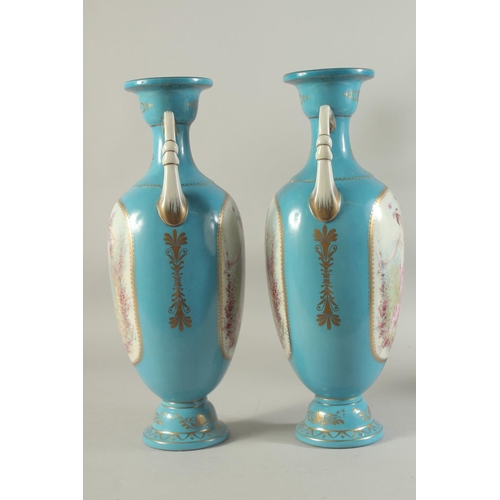 1157 - A PAIR OF BLUE SEVRES DESIGN TWO HANDLED VASES with panels of cupids.