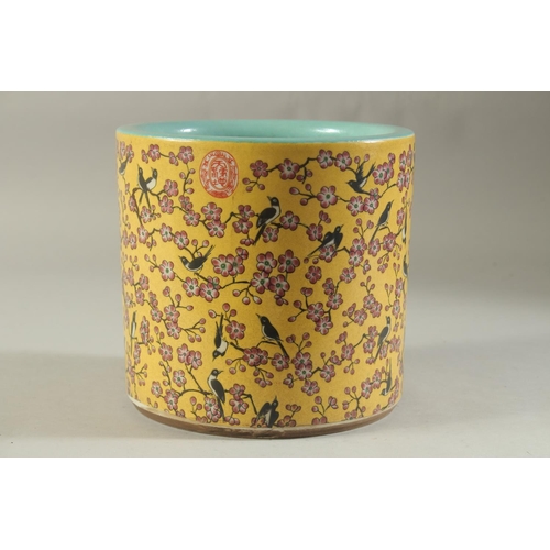 1189 - A CHINESE PORCELAIN YELLOW GROUND BRUSH POT with birds and flowers. 7ins high.