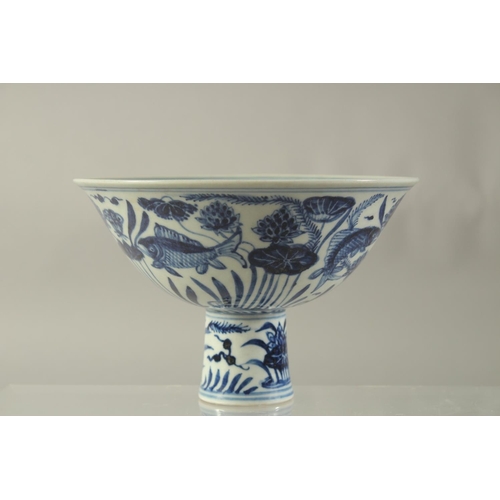 1194 - A CHINESE PORCELAIN BLUE AND WHITE STEM CUP painted with fish. 6.5ins high.