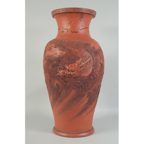 1204 - A LARGE CHINESE TERRA COTTA VASE carved with dragons and figures. 26ins high.