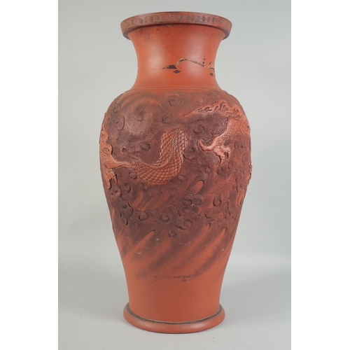 1204 - A LARGE CHINESE TERRA COTTA VASE carved with dragons and figures. 26ins high.