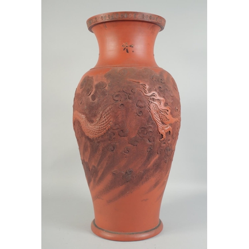 1204 - A LARGE CHINESE TERRA COTTA VASE carved with dragons and figures. 26ins high.