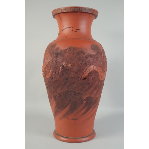 1204 - A LARGE CHINESE TERRA COTTA VASE carved with dragons and figures. 26ins high.