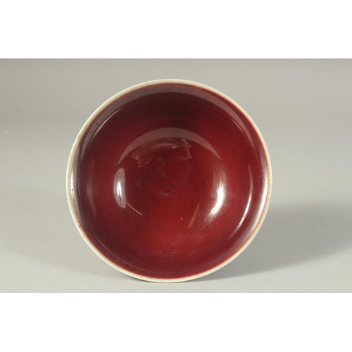 1211 - A CHINESE COPPER RED GLAZE PORCELAIN STEM CUP. 15cm diameter.