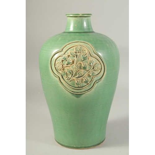 1215 - A CHINESE GREEN GLAZE JIZHOU VASE, with two relief floral panels. 29.5cm high.