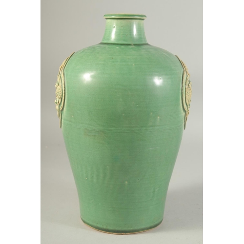 1215 - A CHINESE GREEN GLAZE JIZHOU VASE, with two relief floral panels. 29.5cm high.