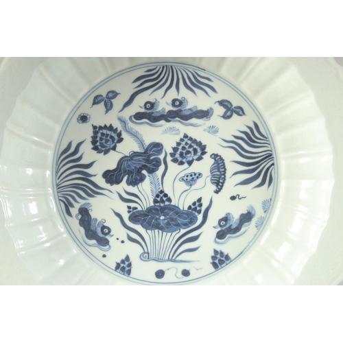 1217 - A CHINESE BLUE AND WHITE PETAL FORM LOTUS CHARGER, with ducks and aquatic flora. 41cm diameter.