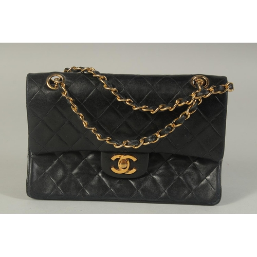 1317 - A CHANEL BLACK PADDED LEATHER BAG, 8ins long with entwined gilt and leather chain, 14ins long.