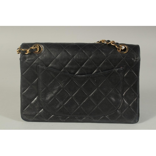 1317 - A CHANEL BLACK PADDED LEATHER BAG, 8ins long with entwined gilt and leather chain, 14ins long.