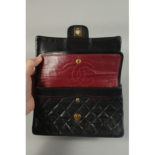 1317 - A CHANEL BLACK PADDED LEATHER BAG, 8ins long with entwined gilt and leather chain, 14ins long.