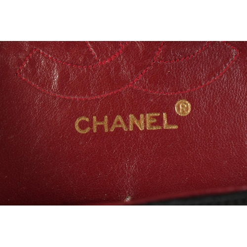 1317 - A CHANEL BLACK PADDED LEATHER BAG, 8ins long with entwined gilt and leather chain, 14ins long.