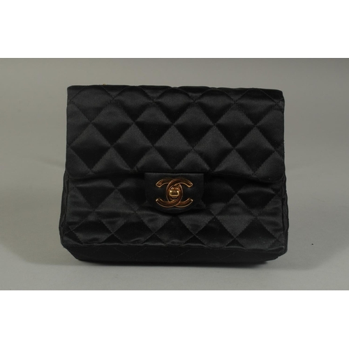 1321 - A SMALL CHANEL PADDED BLACK EVENING BAG 6.5ins long with entwined gilt metal and leather chain, 20in... 