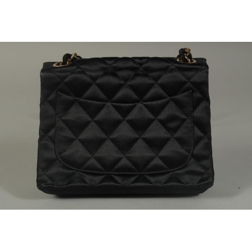 1321 - A SMALL CHANEL PADDED BLACK EVENING BAG 6.5ins long with entwined gilt metal and leather chain, 20in... 