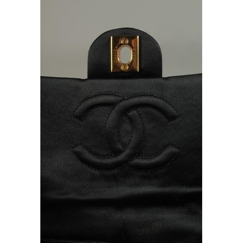 1321 - A SMALL CHANEL PADDED BLACK EVENING BAG 6.5ins long with entwined gilt metal and leather chain, 20in... 