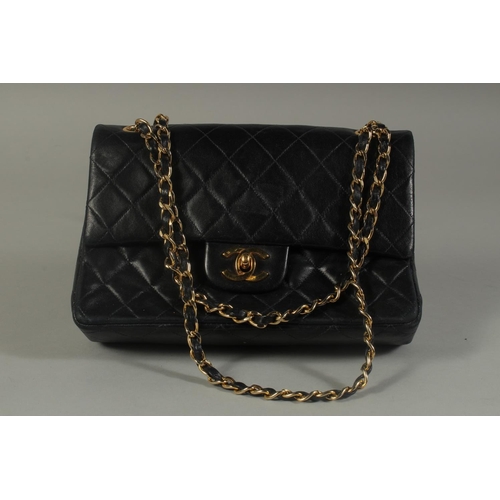 1322 - A SMALL CHANEL PADDED BLACK LEATHER BAG, 7.5ins long with entwined gilt and leather strap, 14ins lon... 