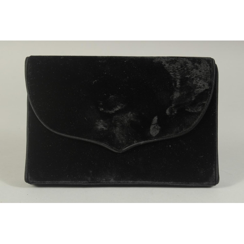 1327 - A CATHERINE WALKER, LONDON, BLACK VELVET EVENING BAG, the inside with a mirror. 7.5ins long.